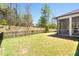 Backyard featuring manicured lawn, black fence and screened in patio with wooded backdrop at 330 Middleton Pl, Chapel Hill, NC 27516