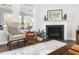 Living room chair next to corner fireplace with dark wood floors and light interior at 330 Middleton Pl, Chapel Hill, NC 27516