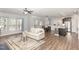 Open concept living room featuring a comfortable sofa, hardwood floors, and a view of the kitchen at 3360 Bordwell Ridge Dr, New Hill, NC 27562