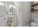 Clean bathroom featuring a pedestal sink, toilet, and wall shelves at 34 Tea Olive Ct, Clayton, NC 27520