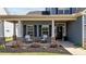 Charming front porch featuring rocking chairs, tasteful decor, and well-manicured landscaping, creating an inviting outdoor space at 34 Tea Olive Ct, Clayton, NC 27520