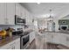 Bright kitchen features white cabinets, granite countertops, and stainless steel appliances; open to the dining and living areas at 34 Tea Olive Ct, Clayton, NC 27520