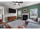 Inviting living room featuring a fireplace, large windows, and a ceiling fan at 34 Tea Olive Ct, Clayton, NC 27520