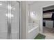 Bright bathroom featuring a soaking tub and a glass-enclosed shower, with a closet behind at 34 Tea Olive Ct, Clayton, NC 27520
