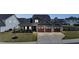 Charming home featuring a three-car garage, landscaped yard, and cozy front porch with seating at 34 Tea Olive Ct, Clayton, NC 27520