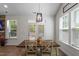 Bright dining area with a wooden table illuminated by a modern chandelier and natural light at 356 Avery Glenn Way, Fuquay Varina, NC 27526