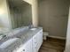 Bathroom featuring dual sinks, a large mirror, white cabinets, and vinyl flooring at 37 Heatherglenn Cir, Princeton, NC 27569
