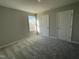 Inviting bedroom with neutral walls, gray carpet, a window, and two doors, creating a serene atmosphere at 37 Heatherglenn Cir, Princeton, NC 27569