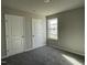 Cozy bedroom featuring neutral walls, two doors, plush gray carpet, and a bright window at 37 Heatherglenn Cir, Princeton, NC 27569