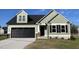 Charming home featuring sage vinyl siding, a black garage door, and tasteful stone accents at 37 Heatherglenn Cir, Princeton, NC 27569