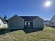 Rear exterior of a home with green siding and a well-maintained backyard and lawn at 37 Heatherglenn Cir, Princeton, NC 27569