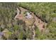 Aerial view of a property with a long driveway, house, and barn surrounded by trees at 3787 Pleasant Hill Church, Siler City, NC 27344