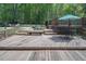 Spacious wooden deck with seating around a fire pit and views of the backyard and a covered pool area at 3787 Pleasant Hill Church, Siler City, NC 27344