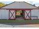 Barn with large sliding doors opening to the stables with wooden railings at 3787 Pleasant Hill Church, Siler City, NC 27344