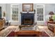 Bright living room featuring a fireplace with a mantle, hardwood floors, and large windows for ample natural light at 3787 Pleasant Hill Church, Siler City, NC 27344