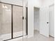 Modern bathroom featuring a glass-enclosed shower with beige tile and a view of the closet with shelves at 40 Rosewood Ln, Youngsville, NC 27596