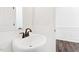 A bright bathroom featuring a curved white sink, dark plumbing fixtures and wainscoting at 40 Rosewood Ln, Youngsville, NC 27596