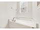 Bright bathroom featuring a white tub under a window with modern fixtures at 40 Rosewood Ln, Youngsville, NC 27596