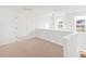 Bright hallway featuring neutral carpet, white walls, a modern light fixture, and natural light through the windows at 40 Rosewood Ln, Youngsville, NC 27596