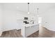 Modern kitchen with white cabinets, quartz countertops, and stainless steel appliances at 40 Rosewood Ln, Youngsville, NC 27596