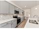 Well-lit kitchen featuring gray cabinets, stainless steel appliances, and quartz countertops at 40 Rosewood Ln, Youngsville, NC 27596