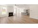 Open-concept living room with a fireplace connected to the kitchen, featuring wood floors at 40 Rosewood Ln, Youngsville, NC 27596