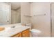 Bathroom featuring wallpaper, wood cabinets, and a glass-enclosed shower at 401 Stinhurst Dr, Durham, NC 27713