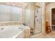 Bathroom with jacuzzi tub, glass shower, and patterned wallpaper at 401 Stinhurst Dr, Durham, NC 27713