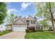 Lovely home featuring a manicured lawn, mature trees, and a two-car garage at 401 Stinhurst Dr, Durham, NC 27713