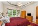 Main bedroom with ceiling fan, parquet floors, and large window with a treed view at 401 Stinhurst Dr, Durham, NC 27713