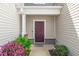 Charming front entrance featuring a recessed porch, brick accents, and a colorful garden at 41 Willow Green Dr, Clayton, NC 27527