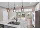 Modern kitchen featuring a granite countertop island with pendant lights, open to the living area and backyard views at 41 Willow Green Dr, Clayton, NC 27527