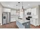 Bright open kitchen with stainless steel appliances, white cabinets, marble countertops and dark hardware at 41 Willow Green Dr, Clayton, NC 27527