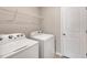 Neutral laundry room featuring a washer, dryer, overhead shelving, and door at 41 Willow Green Dr, Clayton, NC 27527