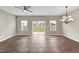 Bright living room with wood floors, ceiling fan, decorative chandelier, and sliding glass doors to the back yard at 41 Willow Green Dr, Clayton, NC 27527