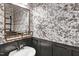 Stylish powder room showcasing black wainscoting, floral wallpaper, and a modern vanity with a chrome faucet at 41 Willow Green Dr, Clayton, NC 27527