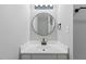 Modern bathroom features a round mirror with a stylish vanity and brushed bronze faucet at 4101 Five Oaks Dr # 40, Durham, NC 27707