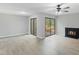 Open living room with fireplace, ceiling fan, wood-look flooring, and dual access to yard at 4101 Five Oaks Dr # 40, Durham, NC 27707