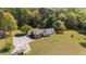 Expansive aerial view of home with manicured lawn, mature trees, and a cozy wraparound deck, perfect for outdoor living at 413 Bayles Rd, Lillington, NC 27546