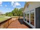 A stained wood back deck with white siding and window and a sunny view of a lawn at 413 Bayles Rd, Lillington, NC 27546