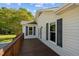 View of back deck showing white siding with dark shutters and the wood stained deck at 413 Bayles Rd, Lillington, NC 27546