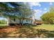Lush backyard view with a home featuring an elevated wooden deck and a visible propane tank at 413 Bayles Rd, Lillington, NC 27546