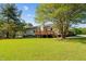 Expansive backyard featuring a wooden deck, lush green lawn, and a glimpse of the serene natural surroundings at 413 Bayles Rd, Lillington, NC 27546