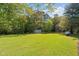 Expansive backyard view showing the shed and greenery with mature trees and green lawn at 413 Bayles Rd, Lillington, NC 27546