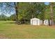Spacious backyard with shed, trailer, and ample greenery under the shade of mature trees at 413 Bayles Rd, Lillington, NC 27546