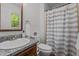 Bathroom featuring granite vanity, toilet, and shower with striped curtain at 413 Bayles Rd, Lillington, NC 27546