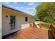 Inviting wooden deck with railings, providing access to the outdoors and views of the lush green surroundings at 413 Bayles Rd, Lillington, NC 27546