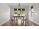 Sunlit dining area with a wooden table and bench seating, complemented by large windows and access to an outdoor deck at 413 Bayles Rd, Lillington, NC 27546