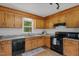 Functional kitchen with wooden cabinets, granite counters, and modern black appliances, optimized for cooking and storage at 413 Bayles Rd, Lillington, NC 27546