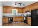 Well-equipped kitchen with wooden cabinets, granite countertops, and black appliances, designed for efficient cooking and storage at 413 Bayles Rd, Lillington, NC 27546